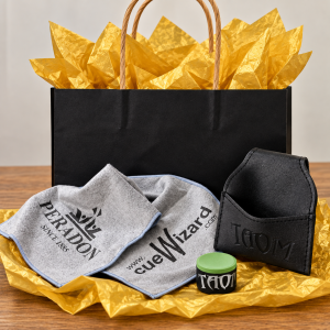 Taom V10 green chalk, empty Taom chalk pouch and grey Peradon cue towel beside black Christmas gift bag with gold tissue